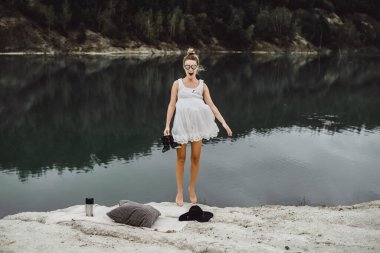 Dünyanın kıyısındaki doğada yaşayan genç bir kadın. Göl, dağlar.