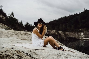 Dünyanın kıyısındaki doğada yaşayan genç bir kadın. Göl, dağlar.