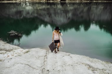Dünyanın kıyısındaki doğada yaşayan genç bir kadın. Göl, dağlar.