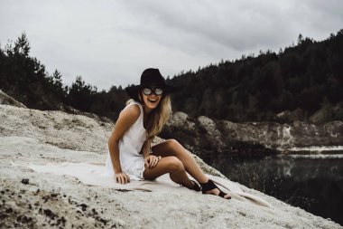 Dünyanın kıyısındaki doğada yaşayan genç bir kadın. Göl, dağlar.