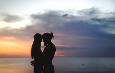 Okyanusta gün batımında aşık bir çift. karışık çift.