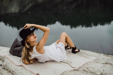 Dünyanın kıyısındaki doğada yaşayan genç bir kadın. Göl, dağlar.