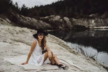 Dünyanın kıyısındaki doğada yaşayan genç bir kadın. Göl, dağlar.