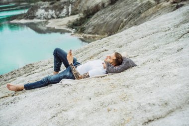 Dünyanın kıyısındaki genç bir adam akıllı telefon kullanıyor.