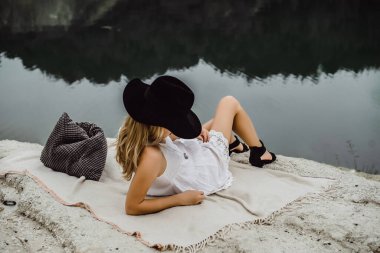 Dünyanın kıyısındaki doğada yaşayan genç bir kadın. Göl, dağlar.