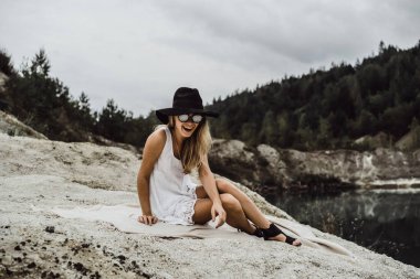 Dünyanın kıyısındaki doğada yaşayan genç bir kadın. Göl, dağlar.