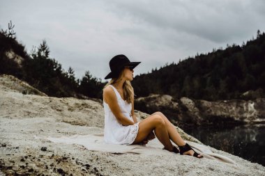 Dünyanın kıyısındaki doğada yaşayan genç bir kadın. Göl, dağlar.