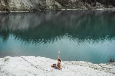 Dünyanın kıyısındaki doğada yaşayan genç bir kadın. Göl, dağlar.