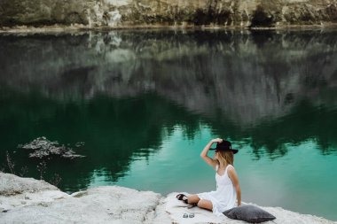 Dünyanın kıyısındaki doğada yaşayan genç bir kadın. Göl, dağlar.