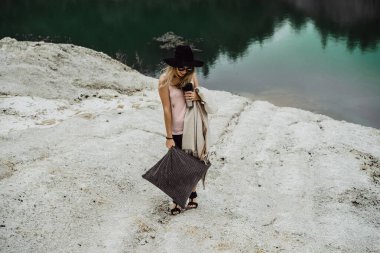 Dünyanın kıyısındaki doğada yaşayan genç bir kadın. Göl, dağlar.