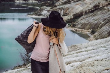 Dünyanın kıyısındaki doğada yaşayan genç bir kadın. Göl, dağlar.