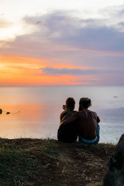 couple in love at sunset on the ocean. mixed couple.