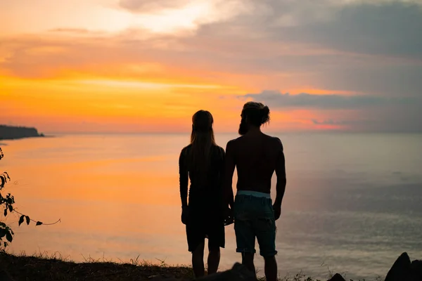 couple in love at sunset on the ocean. mixed couple.