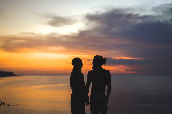 couple in love at sunset on the ocean. mixed couple.