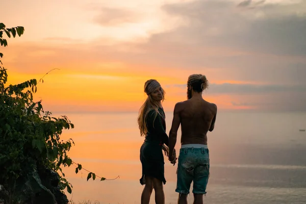 couple in love at sunset on the ocean. mixed couple.