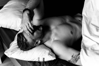 Seksi çıplak genç adam ellerini uzatıyor ve yalan söylerken gülümsüyor.