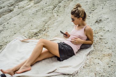 Dünyanın kıyısındaki doğada yaşayan genç bir kadın akıllı fotolar kullanır.