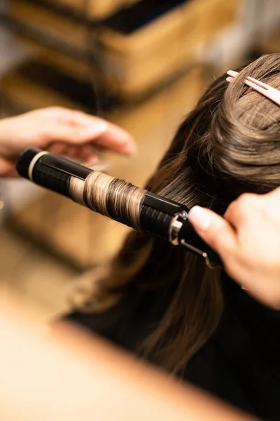 茶色の髪の女性の髪をカールのスタイリスト 女の子髪型気 — ストック写真