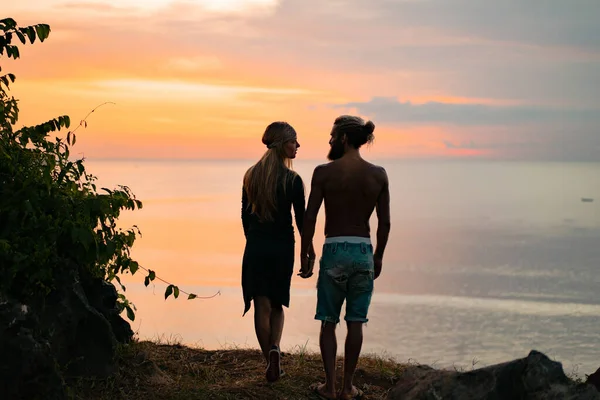 couple in love at sunset on the ocean. mixed couple.