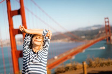 Arka plandaki genç kadın Golden Gate Köprüsü, San Francisco