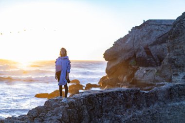 Point Lobos, San Francisco, Kaliforniya Plajları 'nda yağmurluk giyen genç bir kadın.