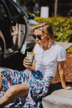 Genç bayan smoothie içiyor, sağlıklı besleniyor..