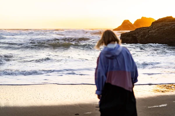 Point Lobos, San Francisco, Kaliforniya Plajları 'nda yağmurluk giyen genç bir kadın.