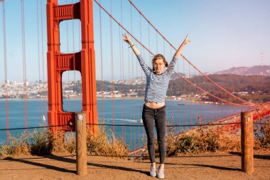 Arka plandaki genç kadın Golden Gate Köprüsü, San Francisco