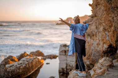 Point Lobos, San Francisco, Kaliforniya Plajları 'nda yağmurluk giyen genç bir kadın.