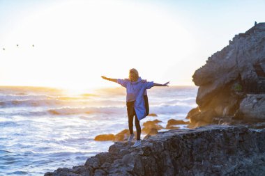 Point Lobos, San Francisco, Kaliforniya Plajları 'nda yağmurluk giyen genç bir kadın.