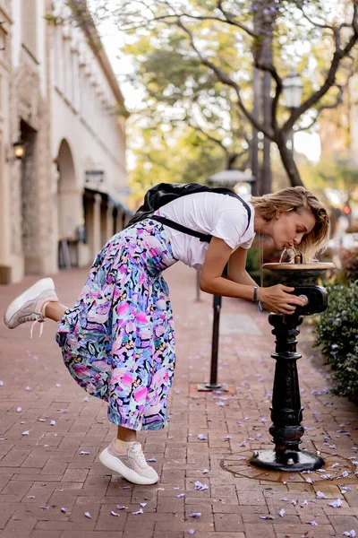 Uma Jovem Caminha Pela Cidade Bebe Uma Fonte Bebida Santa — Fotografia de Stock