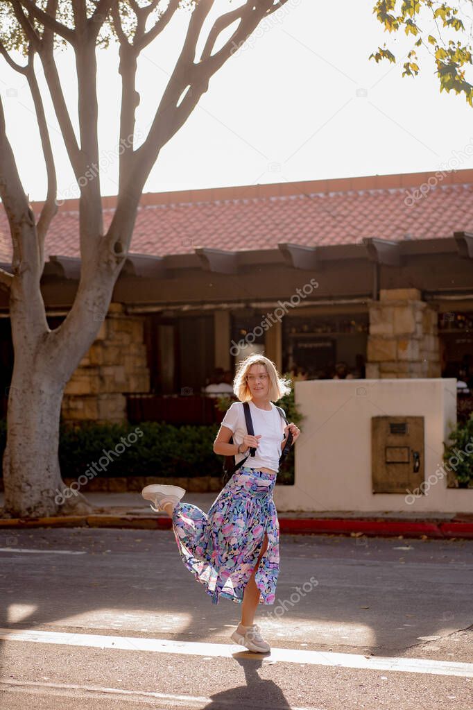 Beautiful blonde young woman walks around the city streets of Santa Barbara, California, USA