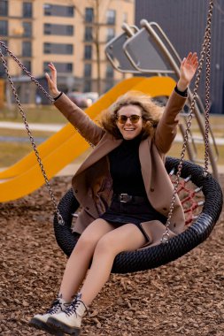 Mutlu, çekici, modaya uygun, genç bir kadın oynarken gülüyor