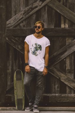 Hippi tarzı adam. Sıradan giyinmiş kaykaylı genç bir kaykaycı 