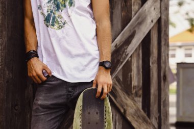 Hippi tarzı adam. Sıradan giyinmiş kaykaylı genç bir kaykaycı 