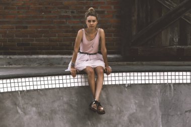 Güzel genç bir kadın açık havada paten havuzunda poz veriyor.. 