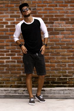 Gündelik kıyafetlerle poz veren genç çekici erkek model.