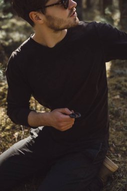 Ormanda yürüyüş yapan bir adam bir pusula kullanıyor, bir yol arıyor, dağlarda bir gezgin..