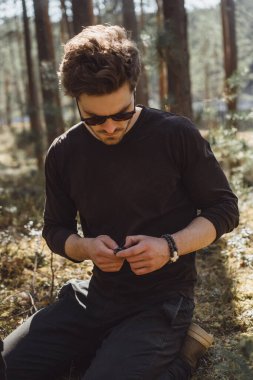 Ormanda yürüyüş yapan bir adam bir pusula kullanıyor, bir yol arıyor, dağlarda bir gezgin..