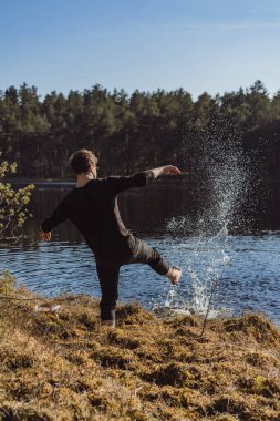 Göldeki adam, ellerini yıkar, sprey sıkar, ormanda dinlenir..