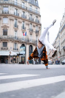 Paris 'te poz veren yakışıklı Afrikalı Amerikalı genç bir adam. Mutlu bir gülümseme, moda tarzı. Sokaklarda çarkı döndürmek