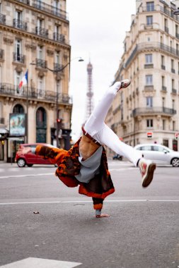 Paris 'te poz veren yakışıklı Afrikalı Amerikalı genç bir adam. Mutlu bir gülümseme, moda tarzı. Sokaklarda çarkı döndürmek