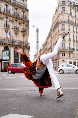 Paris 'te poz veren yakışıklı Afrikalı Amerikalı genç bir adam. Mutlu bir gülümseme, moda tarzı. Sokaklarda çarkı döndürmek