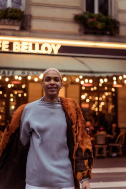 Paris 'te genç, yakışıklı, Afro-Amerikan bir adam. Akşam kafelerinin ışıkları.