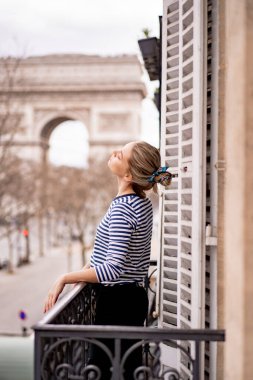 Sabahları Paris 'te balkonda çekici genç bir kadın.