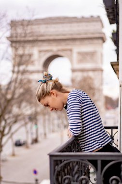 Sabahları Paris 'te balkonda çekici genç bir kadın.