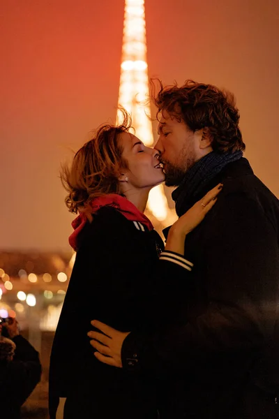 年轻漂亮的夫妇在夜晚亲吻着巴黎的埃菲尔铁塔 — 图库照片