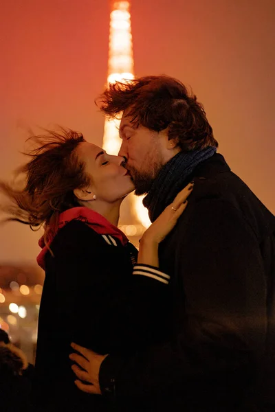 年轻漂亮的夫妇在夜晚亲吻着巴黎的埃菲尔铁塔 — 图库照片
