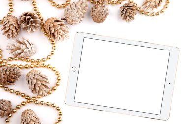 Noel düz mockup masaüstü, çam kozalakları yatıyordu ve tablet üzerinde beyaz bir arka plan