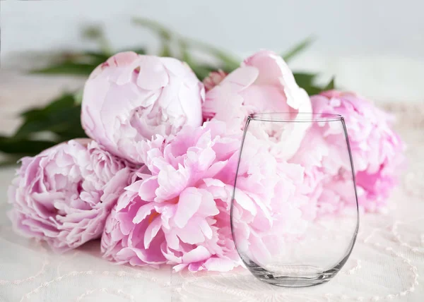 Mockup - stemless wine glass, with peonies behind — Stock Photo, Image